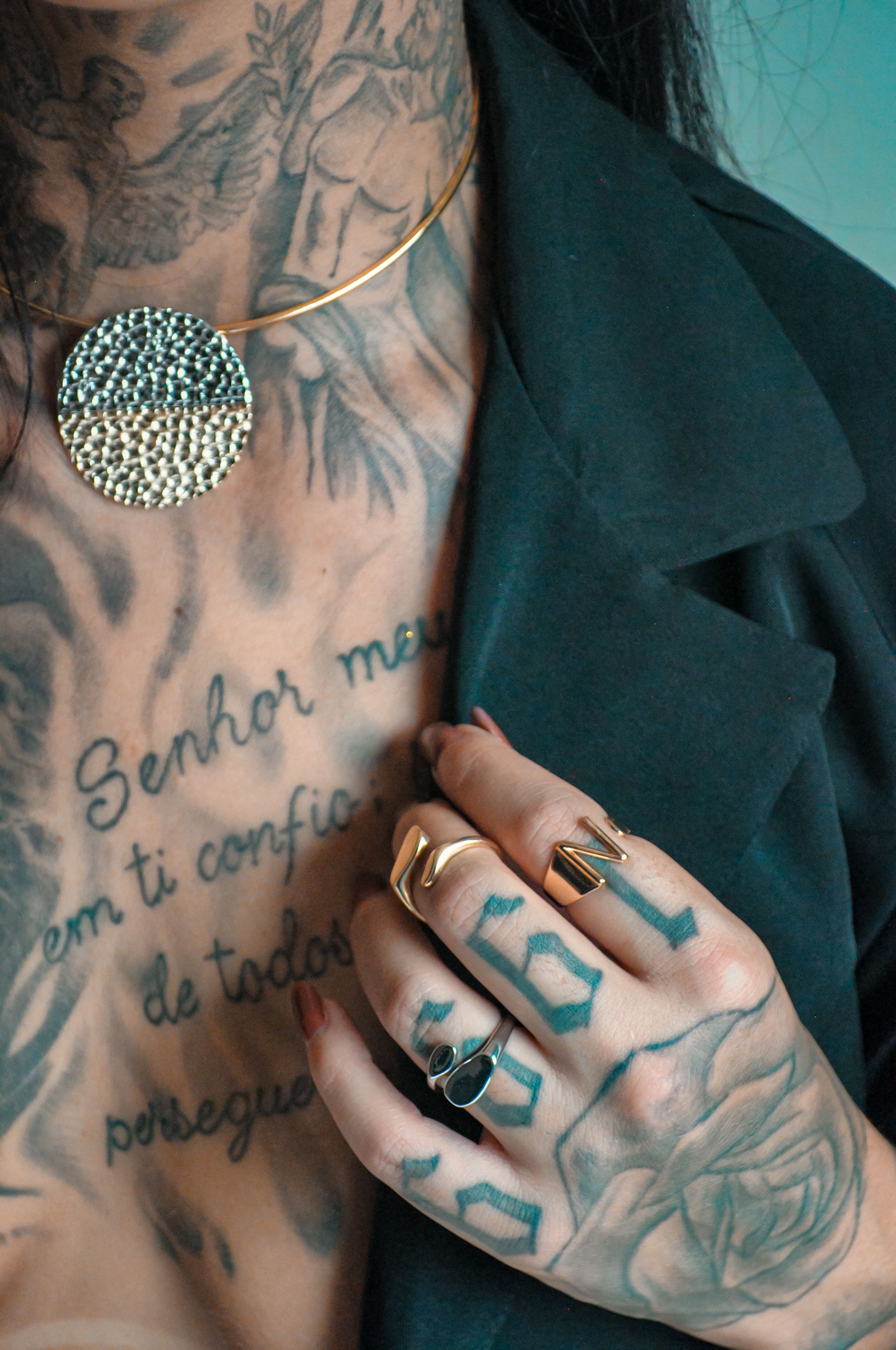 Mãos com tatuagens nos dedos em foto lifestyle